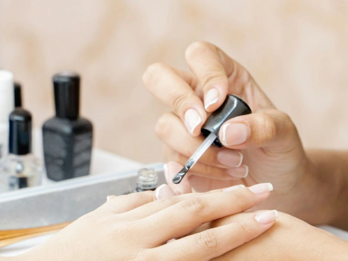 a woman is doing a manicure on a child's hand Organic Beauty Salon